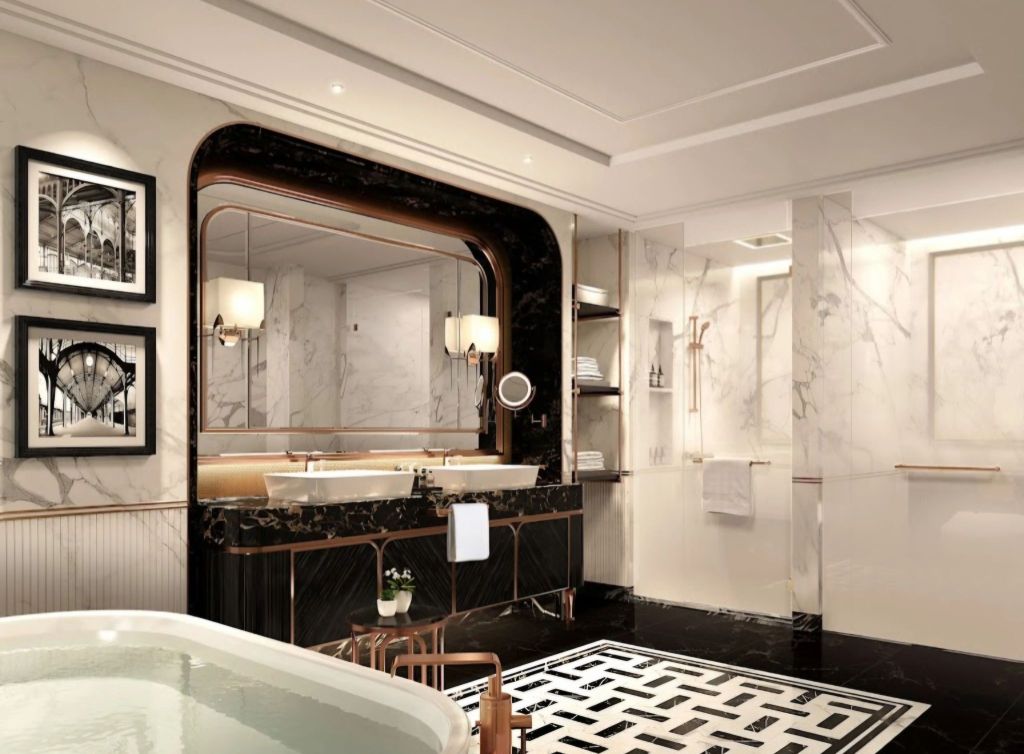 Luxurious bathroom in Fairmont Mumbai featuring marble walls, elegant lighting, dual sinks, and stylish décor.
