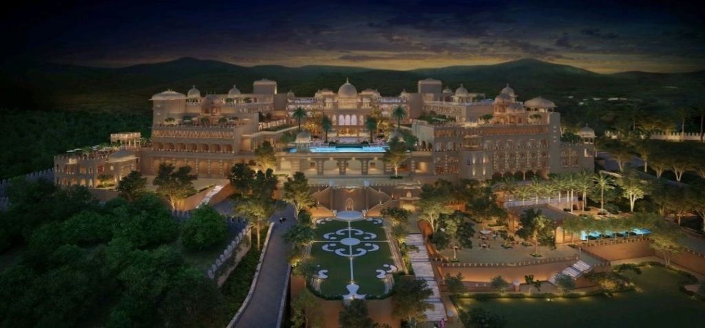 Aerial view of the Fairmont Udaipur Palace, showcasing its regal architecture and beautifully landscaped gardens at dusk.