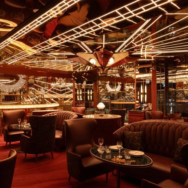 The elegant interior of China Tang Dubai, showcasing Art Deco design elements with intricate lighting and plush seating arrangements.