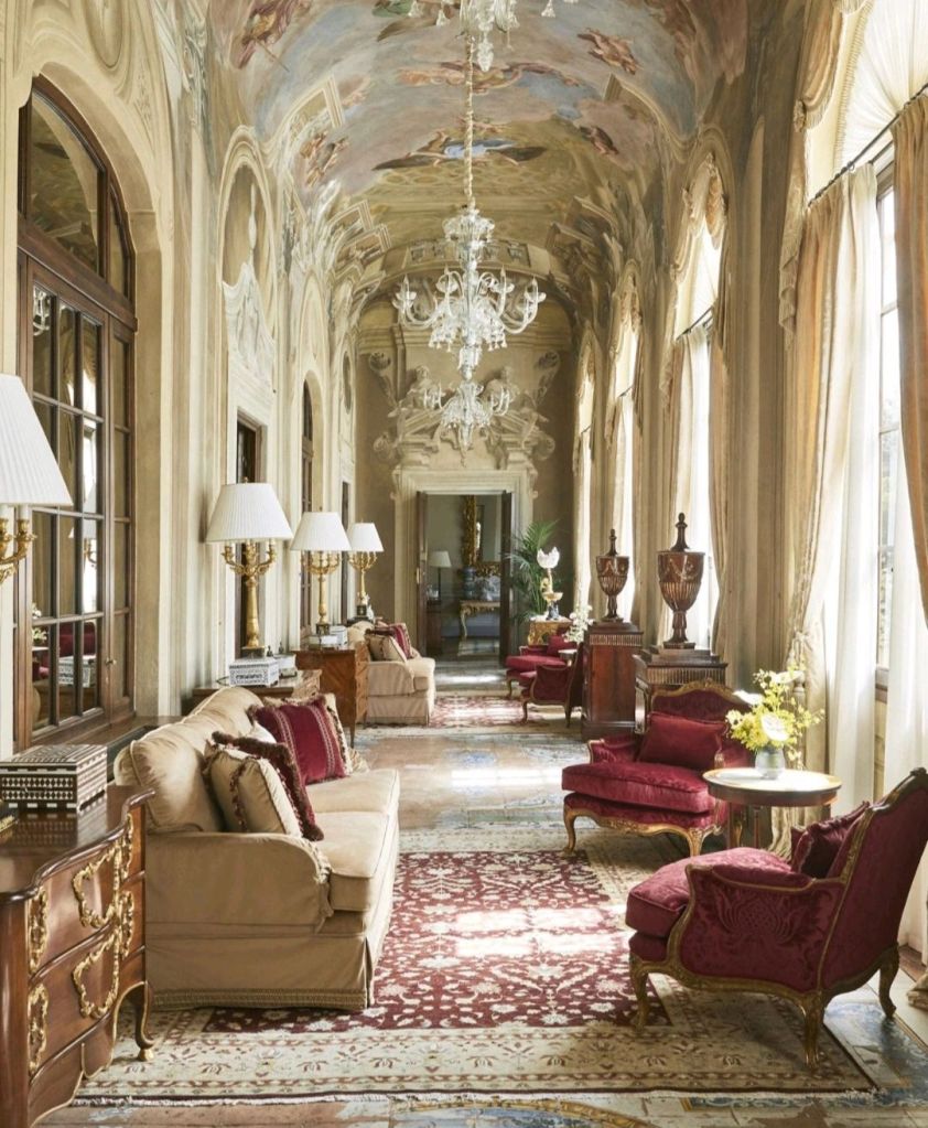 Elegant hotel lobby featuring ornate architecture, plush seating, and decorative chandeliers.