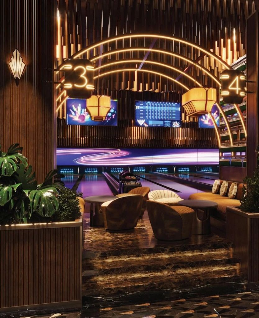 Interior view of Kapitol, a vibrant three-level entertainment venue, featuring stylish lounge seating, lush greenery, and a well-lit bowling area with neon accents.