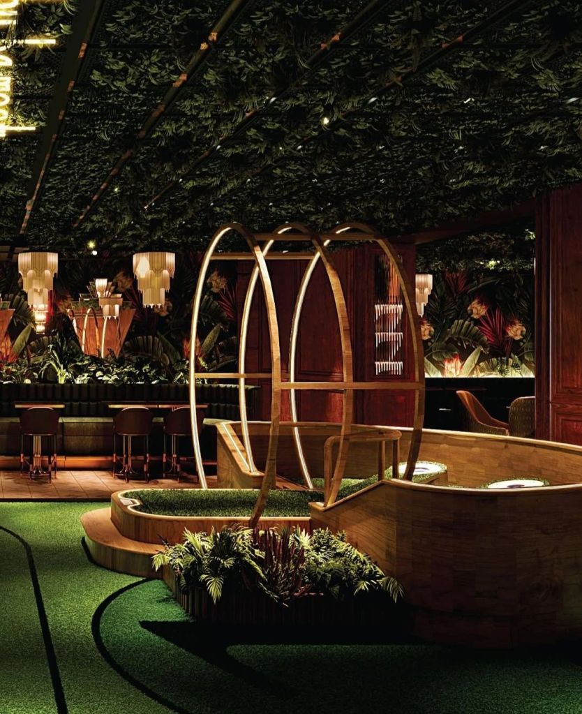 Interior view of the Kapitol venue showcasing lush greenery, stylish lighting, and modern decor designed for entertainment and social interaction.