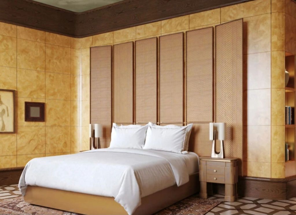 A luxurious hotel room featuring a large bed with white linens, elegant bedside lamps, and decorative wall panels. The walls are adorned with warm, golden tones, and there is a framed piece of art on the wall, creating a sophisticated atmosphere.