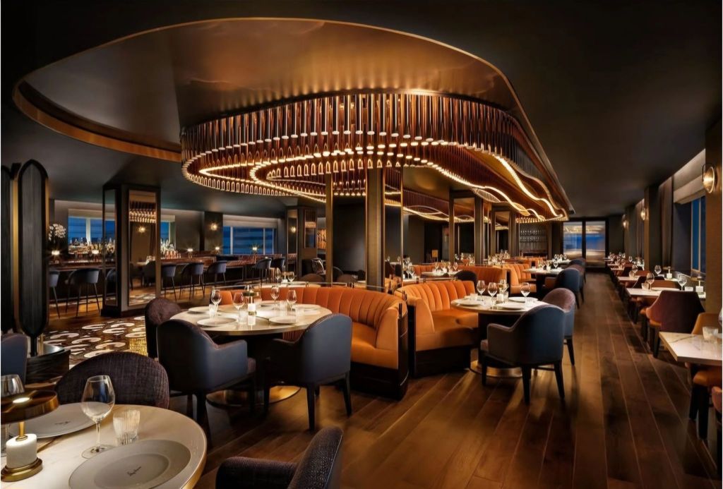 Interior view of the elegantly designed Sky Room at Fairmont Breakers, showcasing luxurious seating, modern lighting, and a sophisticated dining atmosphere.