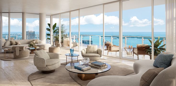 A modern and elegantly designed living space with large glass windows showcasing a waterfront view in Miami, featuring comfortable furniture, natural light, and decorative plants.