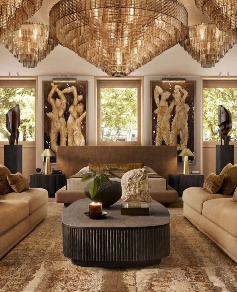 Luxurious lounge area featuring plush sofas, elegant chandeliers, and contemporary artwork, bathed in natural light from large windows.