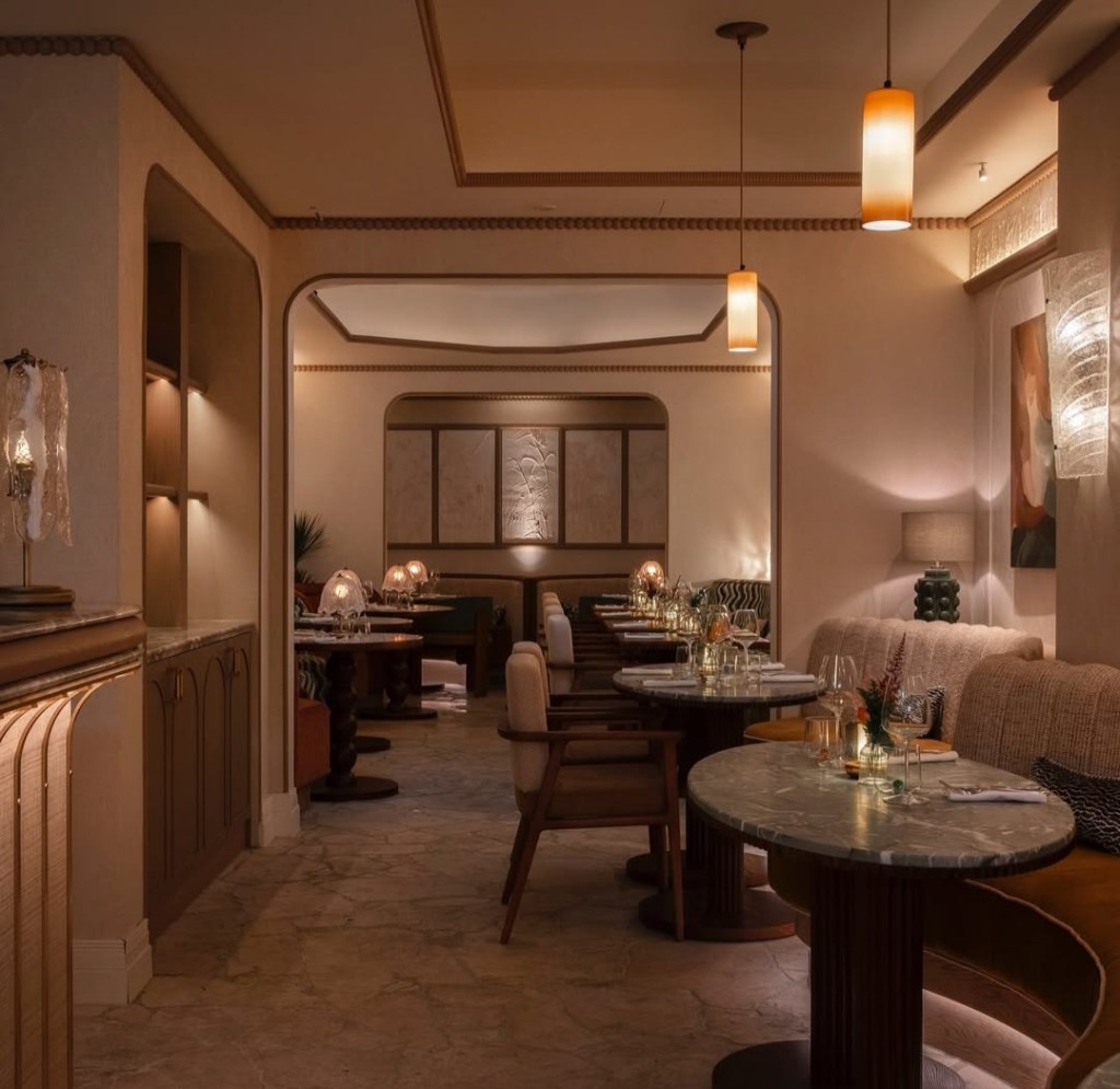 Interior view of SILVA restaurant showcasing a warm, inviting atmosphere with natural textures, soft lighting, and elegantly set tables.