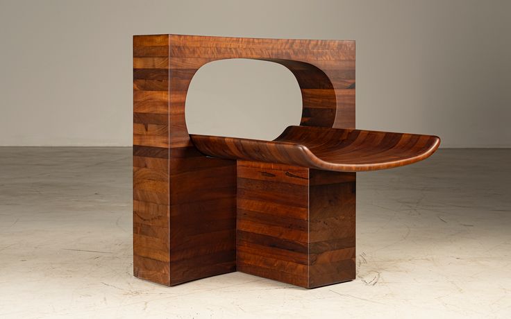 A contemporary wooden bench with a sculptural design, featuring a smooth, curved seat and a rectangular base with a cutout, showcasing craftsmanship and artistic form.