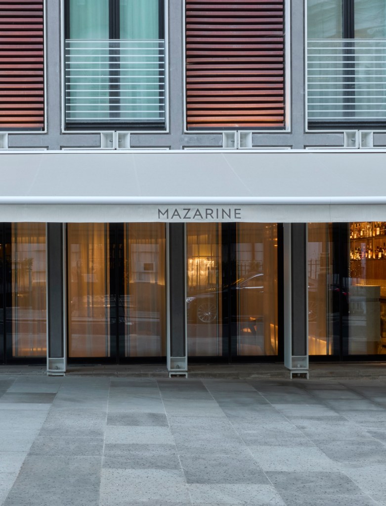 Facade of the Mazarine restaurant showcasing contemporary architecture with large glass windows and an awning.