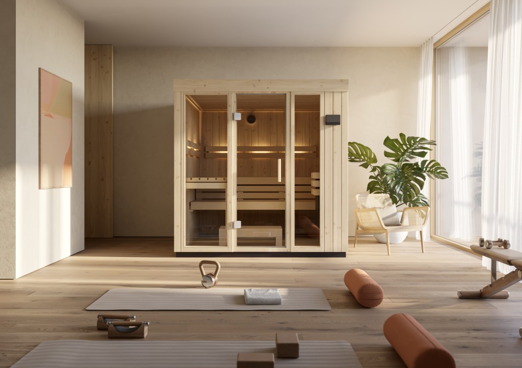 A modern wellness space featuring a wooden sauna, exercise mats, and plants, with natural light streaming through large windows.