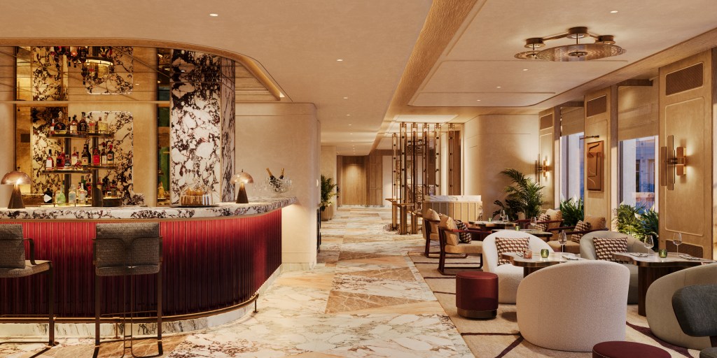 Elegant bar area in a modern hotel lobby featuring a marble counter, stylish seating, and decorative lighting.