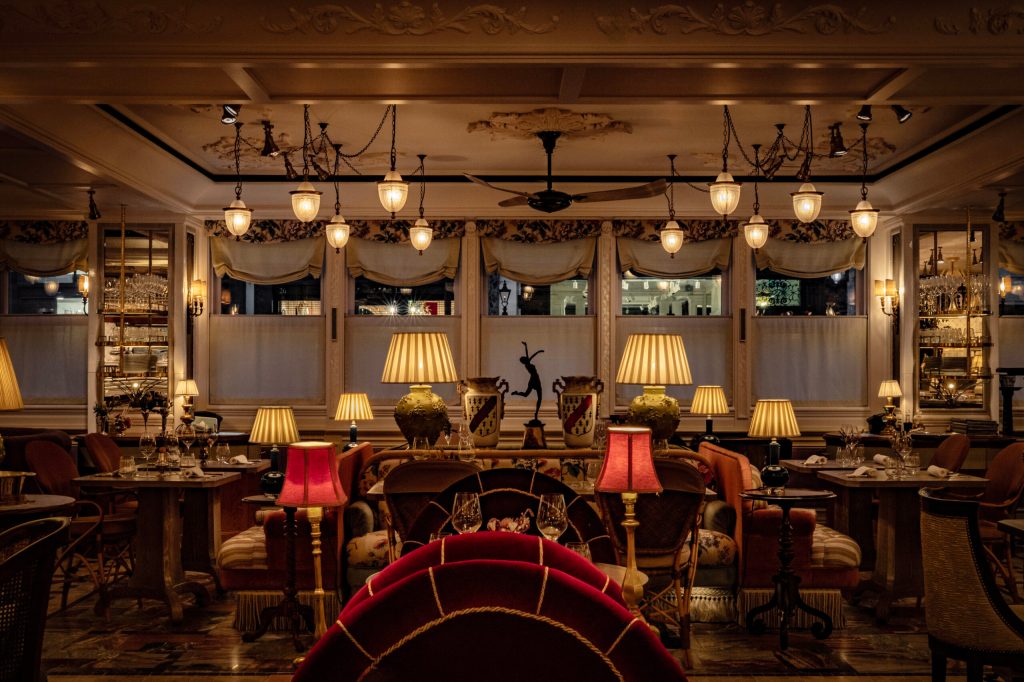 A beautifully decorated restaurant interior featuring elegant lighting, plush seating, and ornate furnishings, creating a warm and inviting atmosphere.
