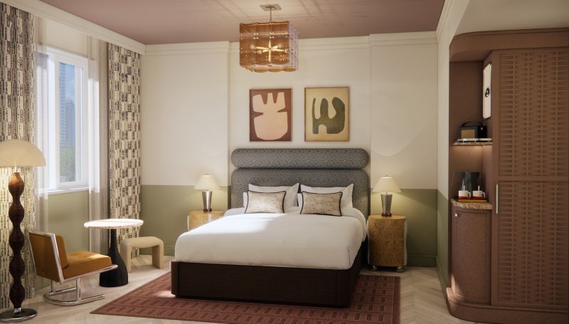 Modern bedroom featuring a large bed with decorative pillows, stylish artwork on the walls, and a mix of contemporary furniture including a chair, side tables, and a lamp.