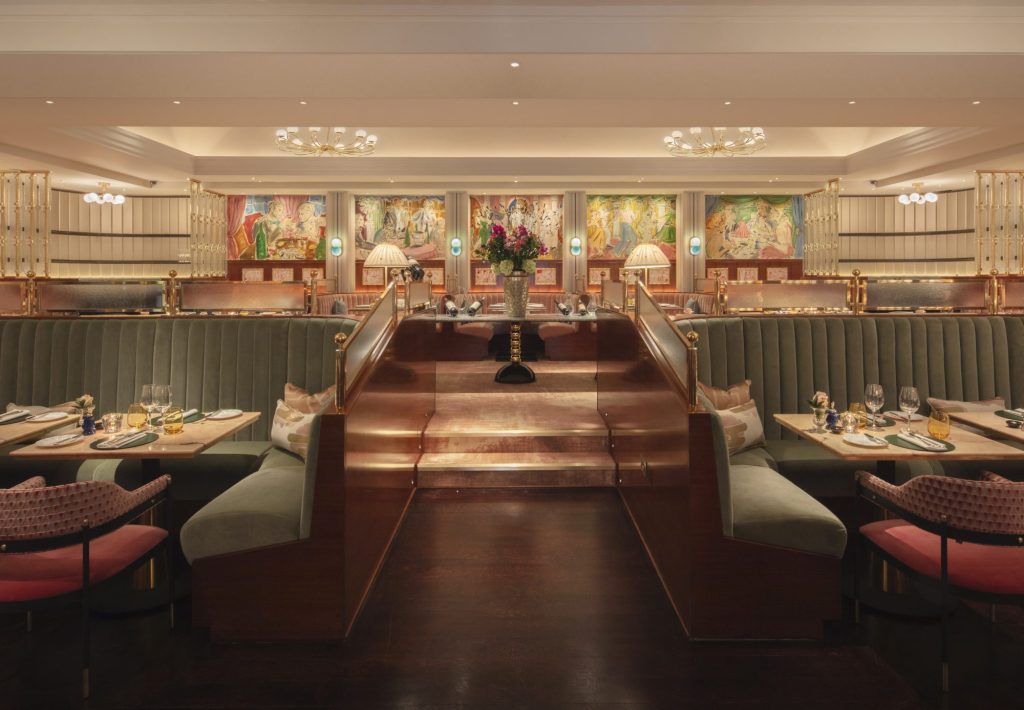 Interior view of an elegant restaurant featuring plush seating, wooden accents, and decorative murals on the walls.